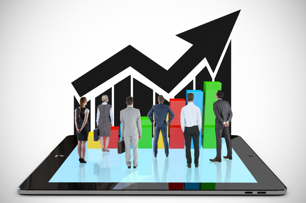 Malaysian businesspeople analyse a competitive market graph on a tablet, reflecting dynamic Google Ad Ranks influenced by real-time auctions and seasonal surges.